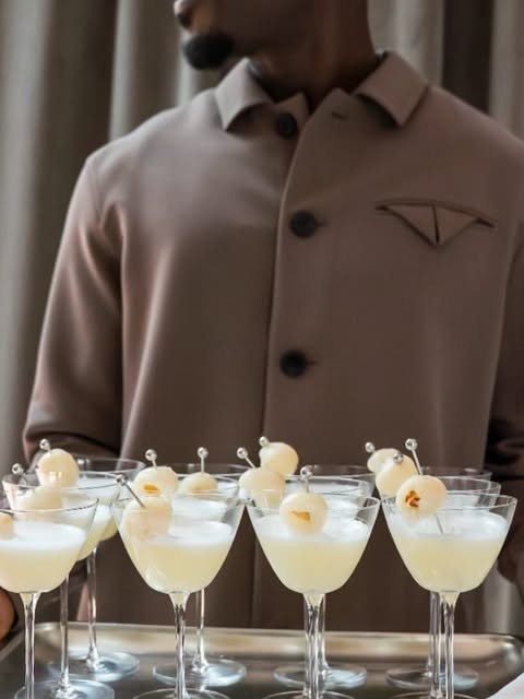 A tray of lychee martinis carried by a bartender